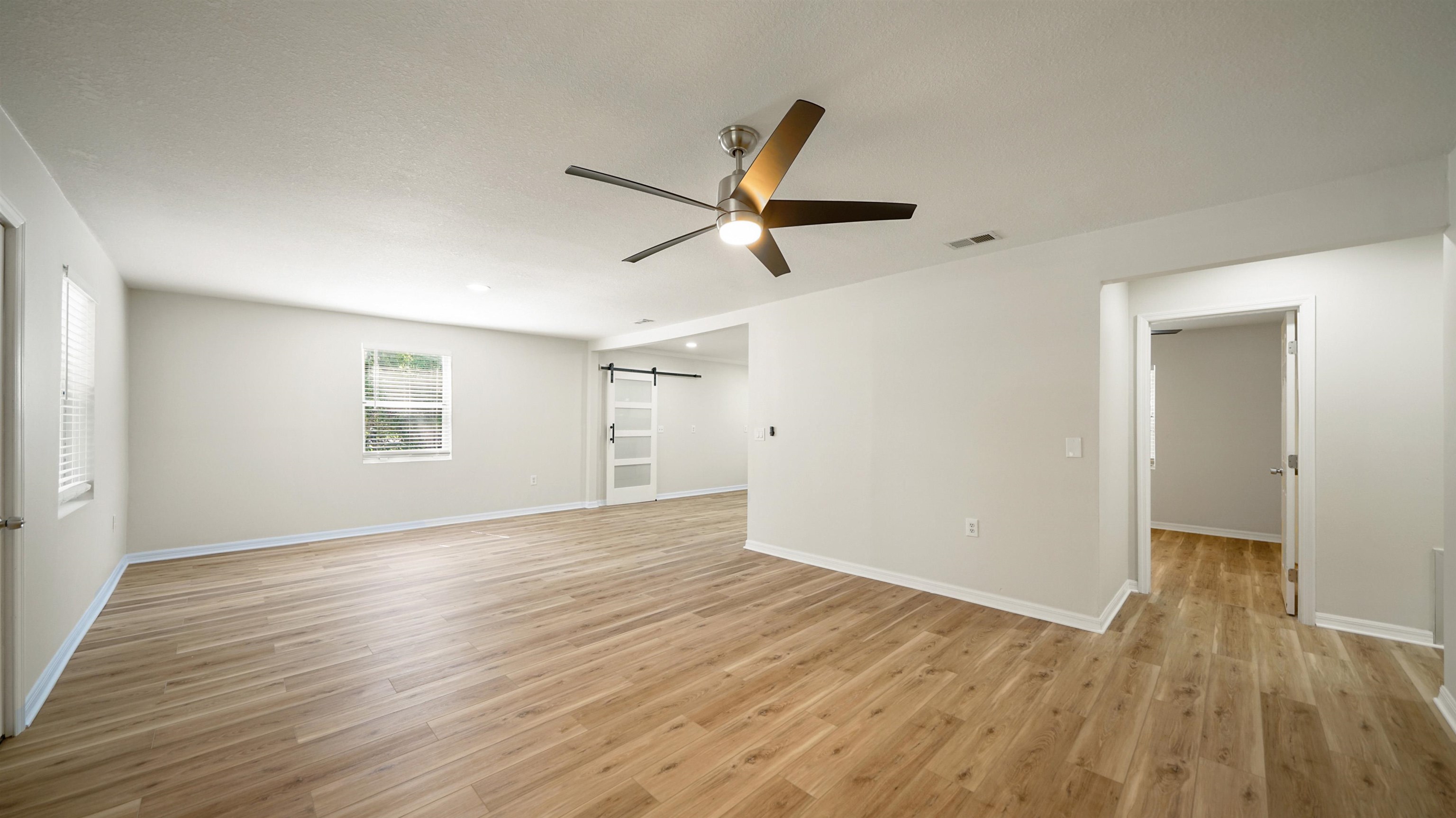 11734 Wynell Road Jacksonville, FL 32218 - Photo 7 of 27 an empty room with wooden floor and windows
