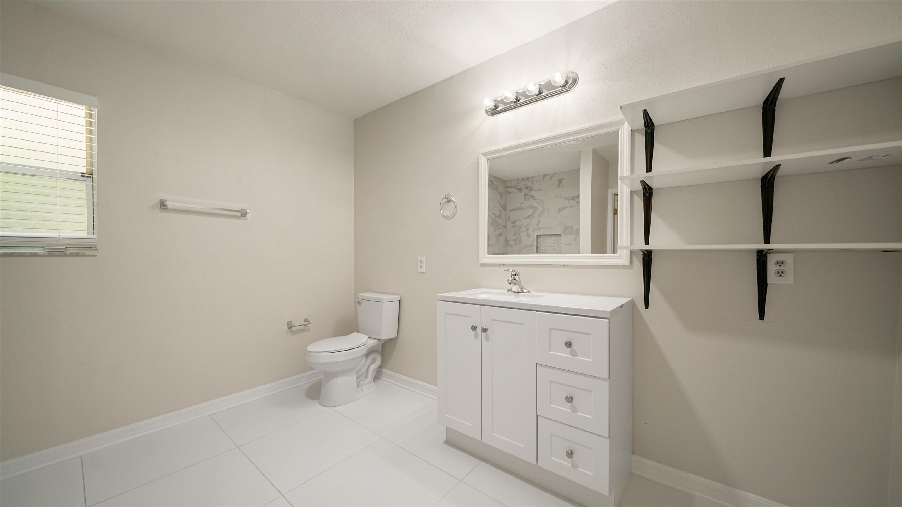 11734 Wynell Road Jacksonville, FL 32218 - Photo 9 of 27 a spacious bathroom with a granite countertop sink a toilet and a mirror