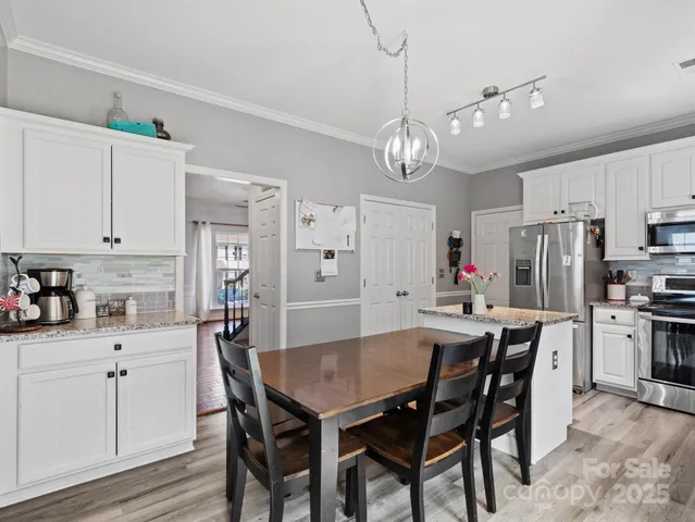a view of kitchen with refrigerator dining table and chairs