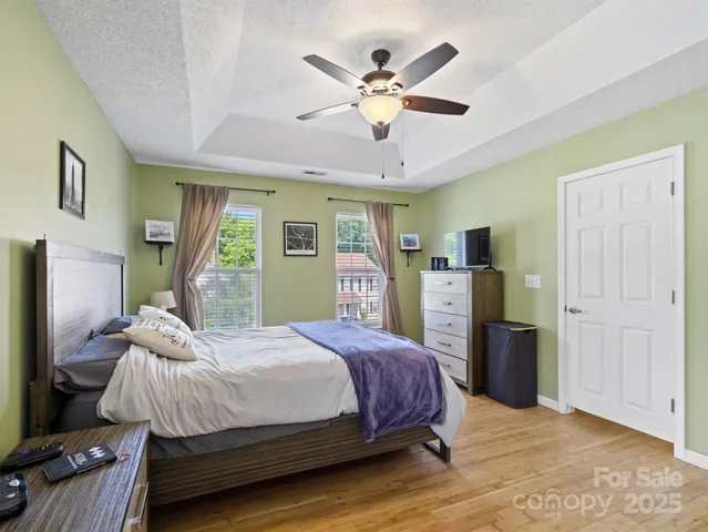 a bedroom with a bed dresser and a large window