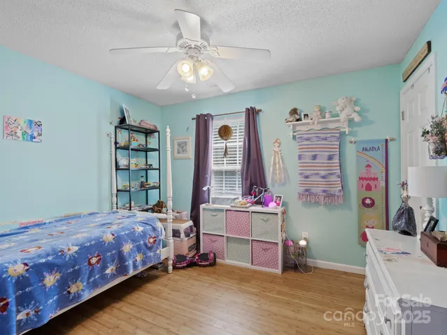 a bedroom with a bed bookshelf and a window