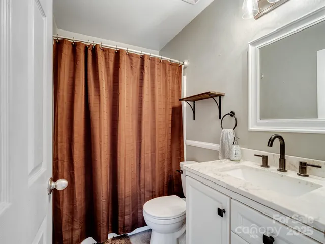 a bathroom with a sink a toilet and a mirror