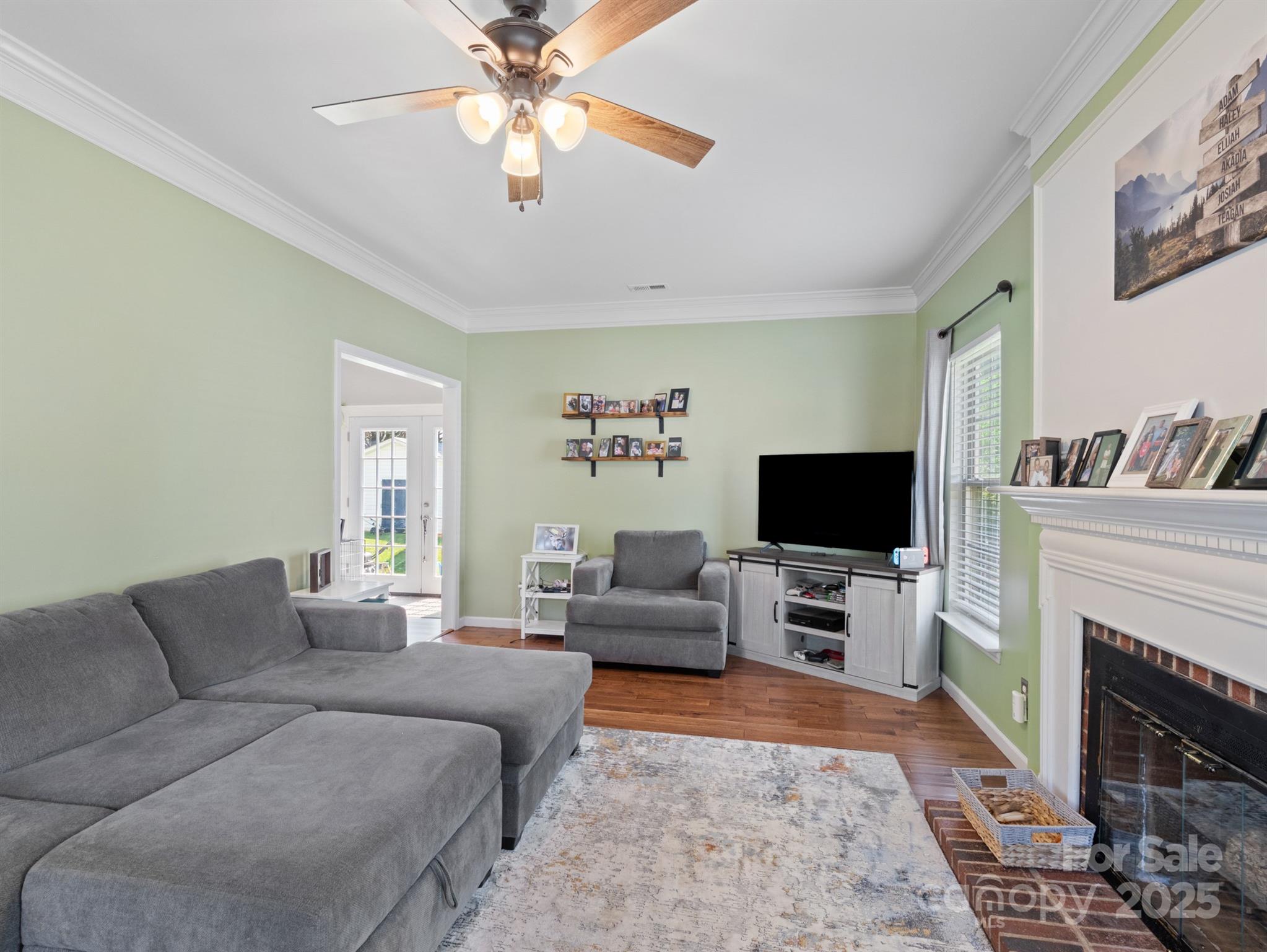 5535 Whispering Wind Lane Indian Trail, NC 28079 - Photo 7 of 25 a living room with furniture a flat screen tv and a fireplace