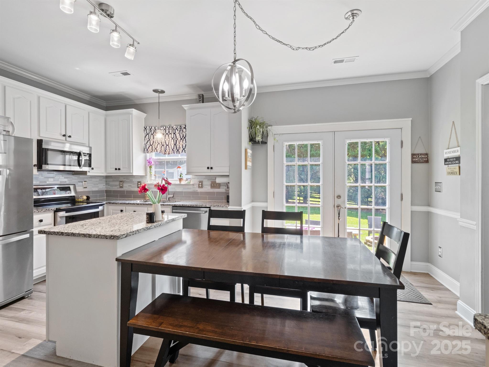 5535 Whispering Wind Lane Indian Trail, NC 28079 - Photo 9 of 25 a view of a dining room with furniture a chandelier and wooden floor