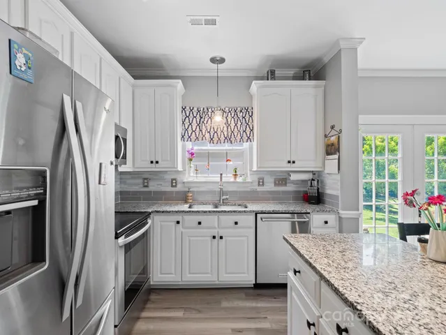 a kitchen with stainless steel appliances granite countertop a sink stove and refrigerator