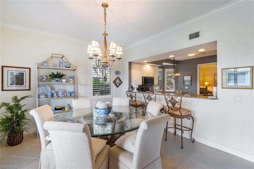 821 Regency Reserve Circle, Unit 3802 Naples, FL 34119 - Photo 12 of 26 a view of a dining room with furniture and chandelier