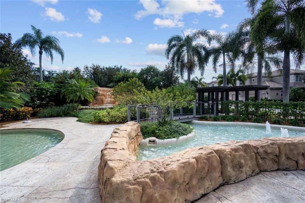 821 Regency Reserve Circle, Unit 3802 Naples, FL 34119 - Photo 24 of 26 a view of swimming pool with a yard and palm trees