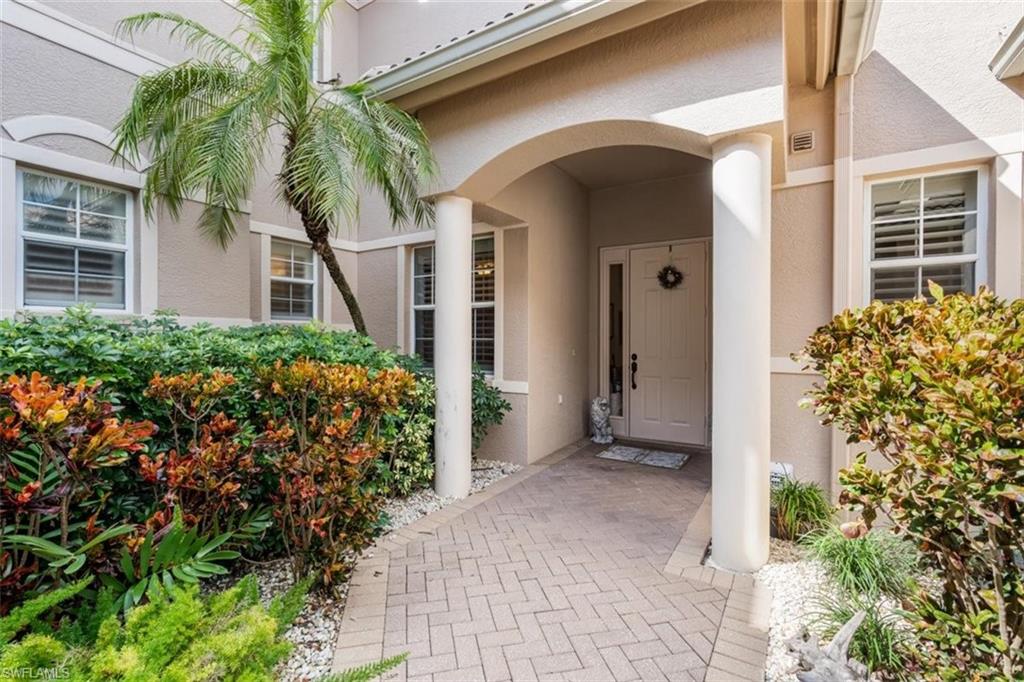 821 Regency Reserve Circle, Unit 3802 Naples, FL 34119 - Photo 3 of 26 a front view of a house with a yard