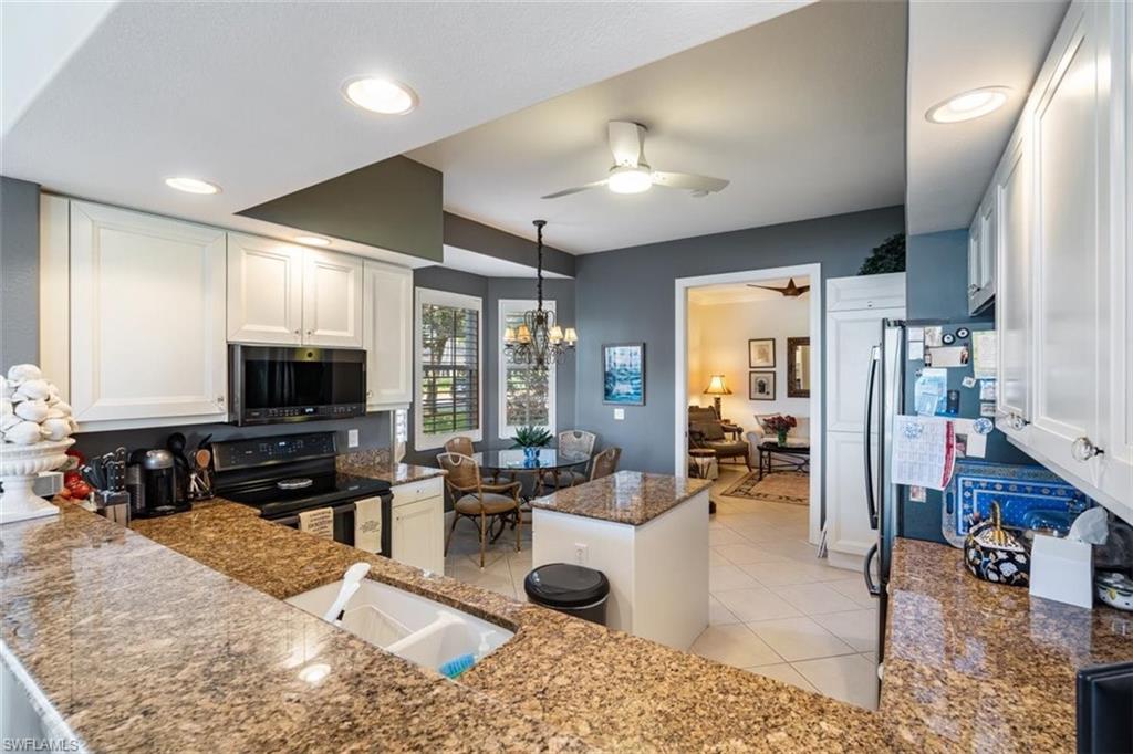 821 Regency Reserve Circle, Unit 3802 Naples, FL 34119 - Photo 9 of 26 a living room with furniture and a flat screen tv