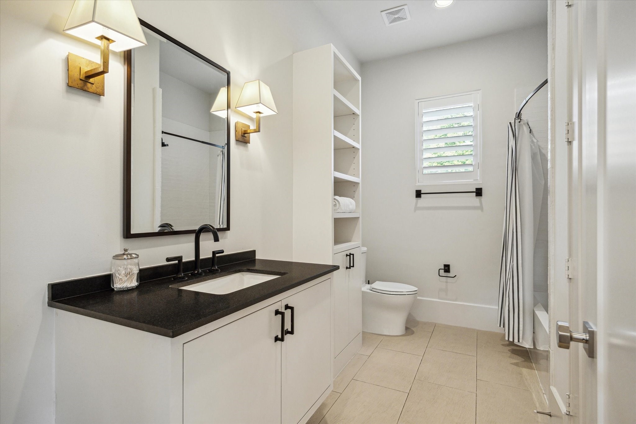 22 East Shady Lane, Unit E Houston, TX 77063 - Photo 36 of 50 a bathroom with a granite countertop sink a toilet and a mirror