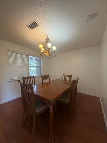 a view of a dining room with furniture and chandelier