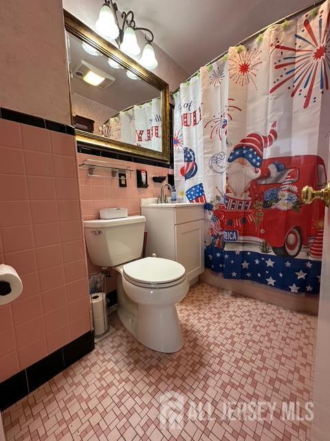 78 Schoder Avenue Woodbridge, NJ 07095 - Photo 7 of 26 a bathroom with a toilet and a shower curtain