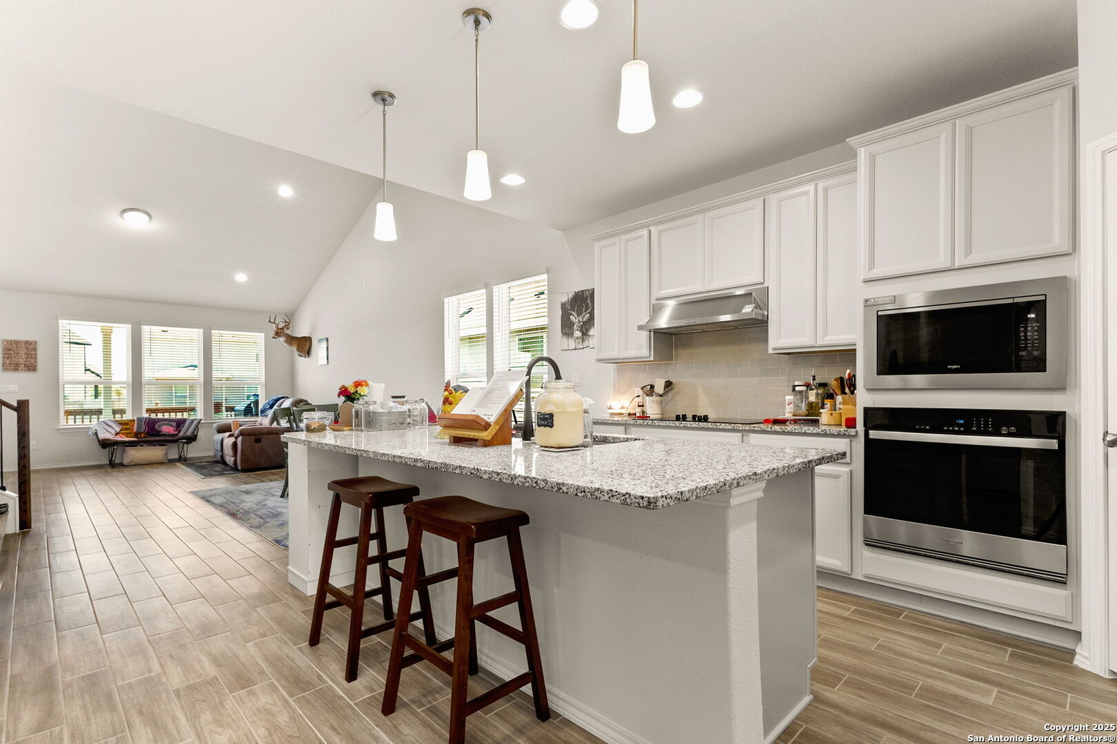4012 Wild Bloom Road Seguin, TX 78155 - Photo 3 of 26 a kitchen with stainless steel appliances granite countertop a stove a sink a microwave a center island and a cabinets