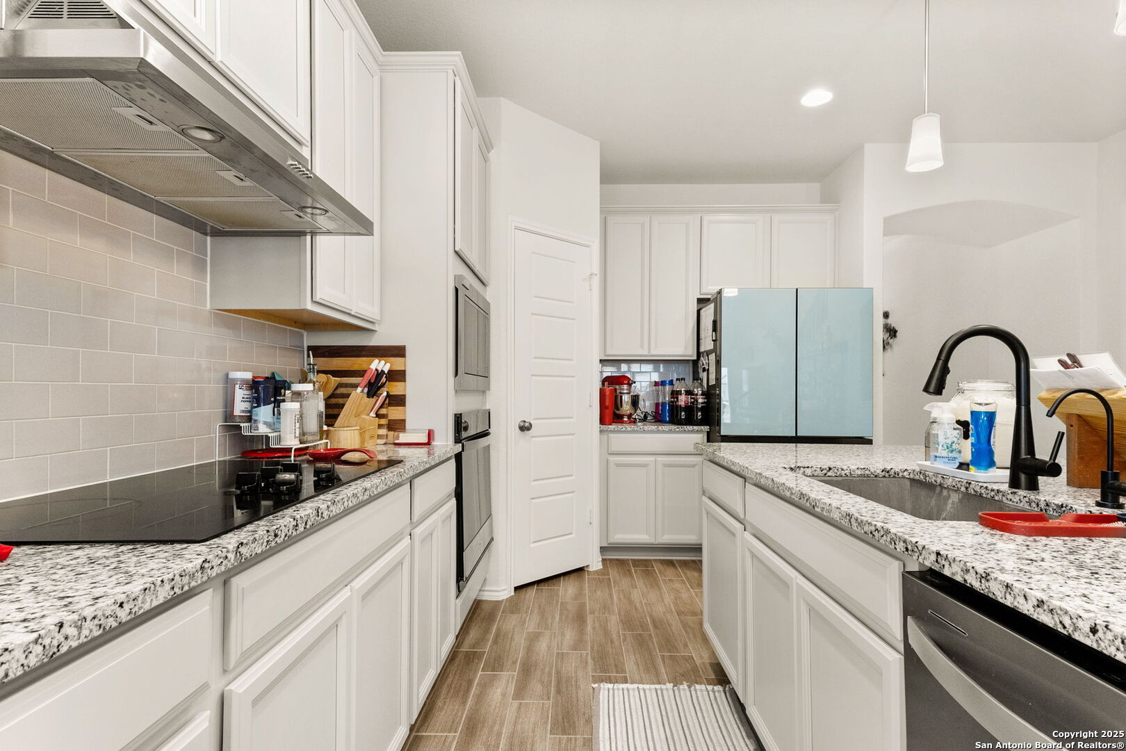 4012 Wild Bloom Road Seguin, TX 78155 - Photo 5 of 26 a kitchen with granite countertop a sink stainless steel appliances and cabinets