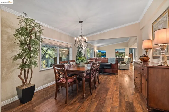 a view of a dining room with furniture a chandelier and wooden floor