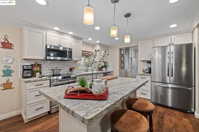 a kitchen with stainless steel appliances granite countertop a sink refrigerator and microwave