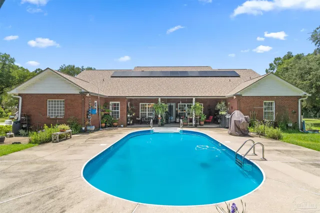 a view of a house with swimming pool and a yard