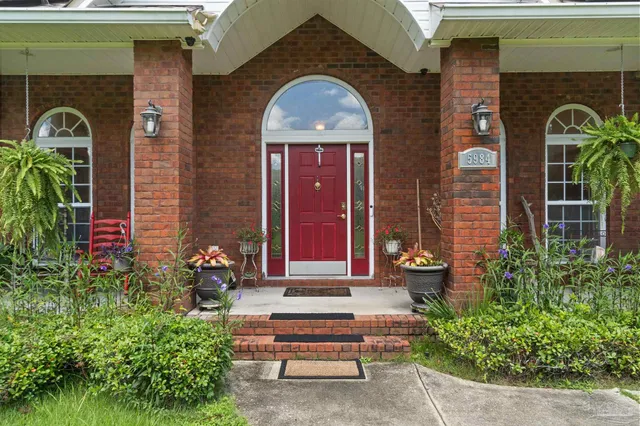 a front view of a house with plants