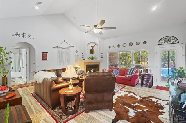 a living room with fireplace furniture and a large window