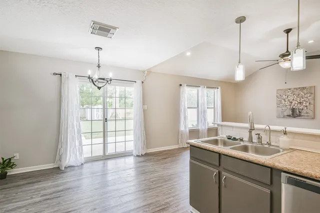 a bathroom with a double vanity sink a large mirror and wooden floor