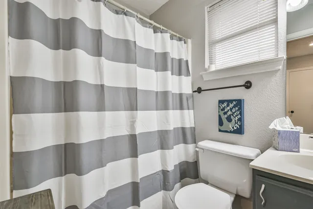 a white toilet sitting next to a shower curtain