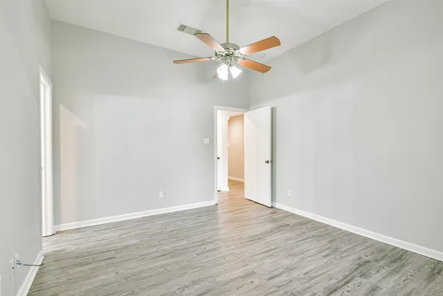 a view of an empty room with wooden floor
