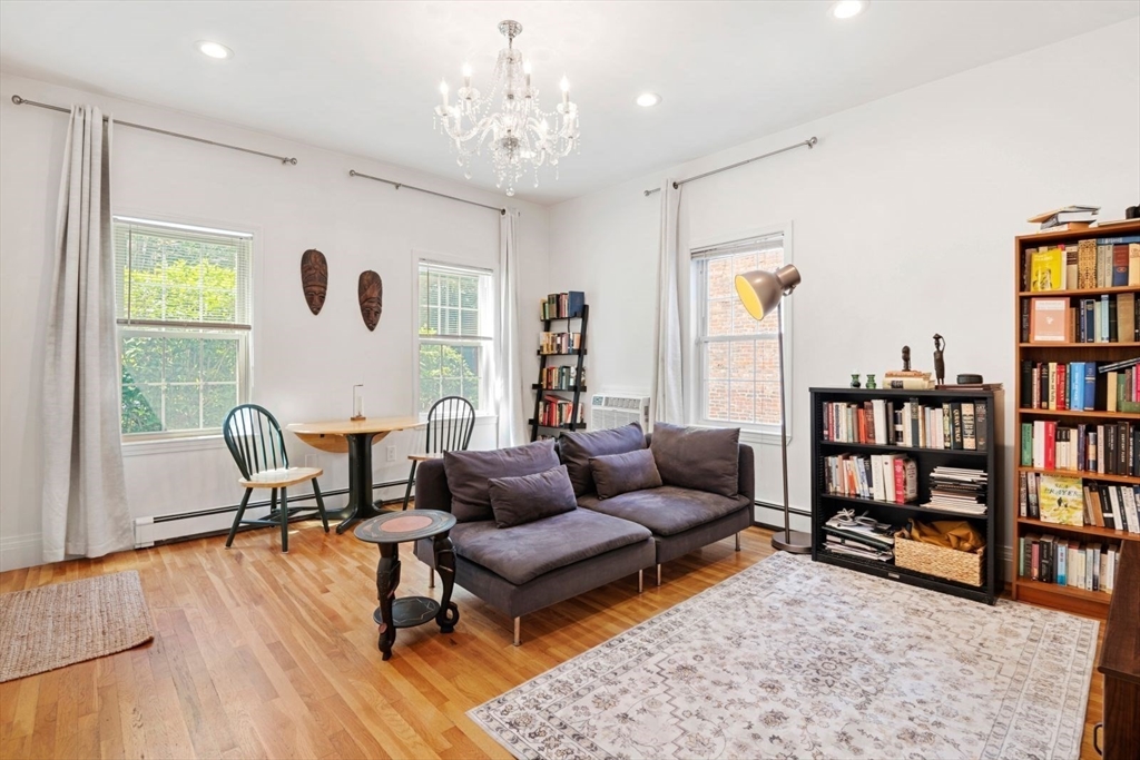 249 Roxbury Street, Unit 1 Boston, MA 02119 - Photo 1 of 19 a living room with furniture and a book shelf