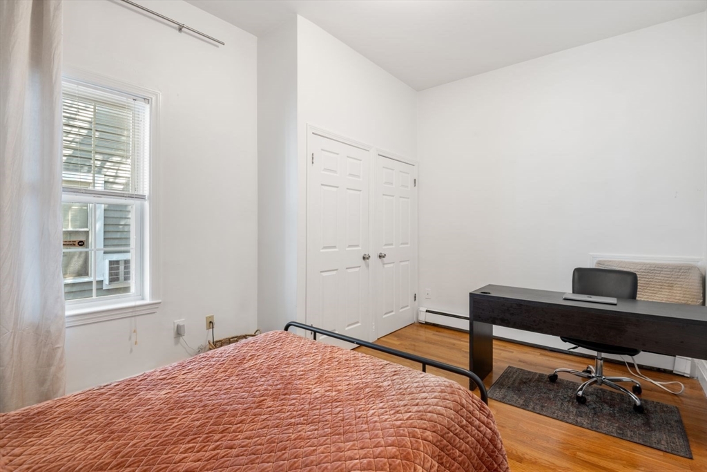 249 Roxbury Street, Unit 1 Boston, MA 02119 - Photo 16 of 19 a bedroom with a bed and a desk