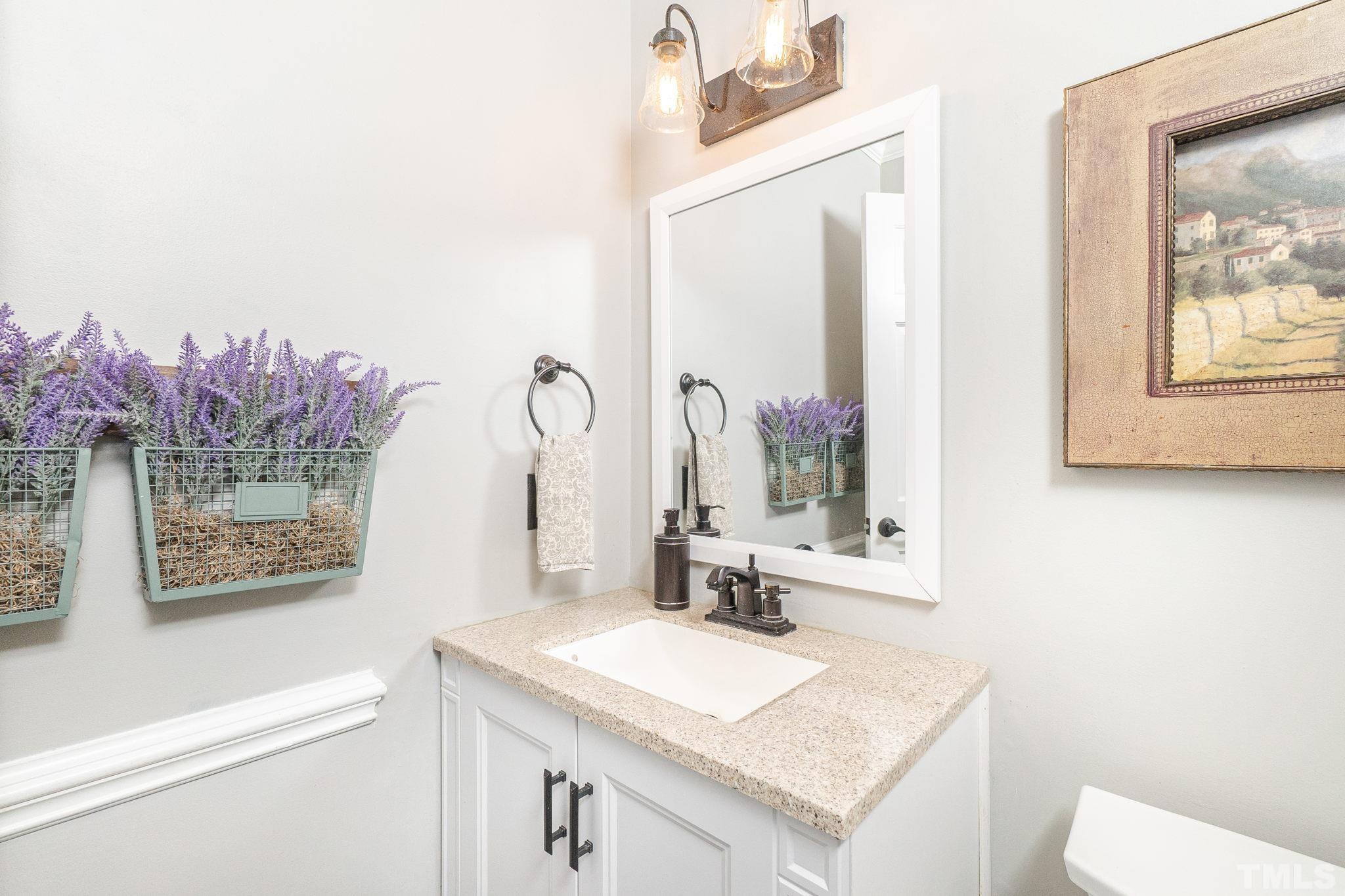 6313 Craig Road Durham, NC 27712 - Photo 15 of 38 a bathroom with a granite countertop sink a toilet and a mirror