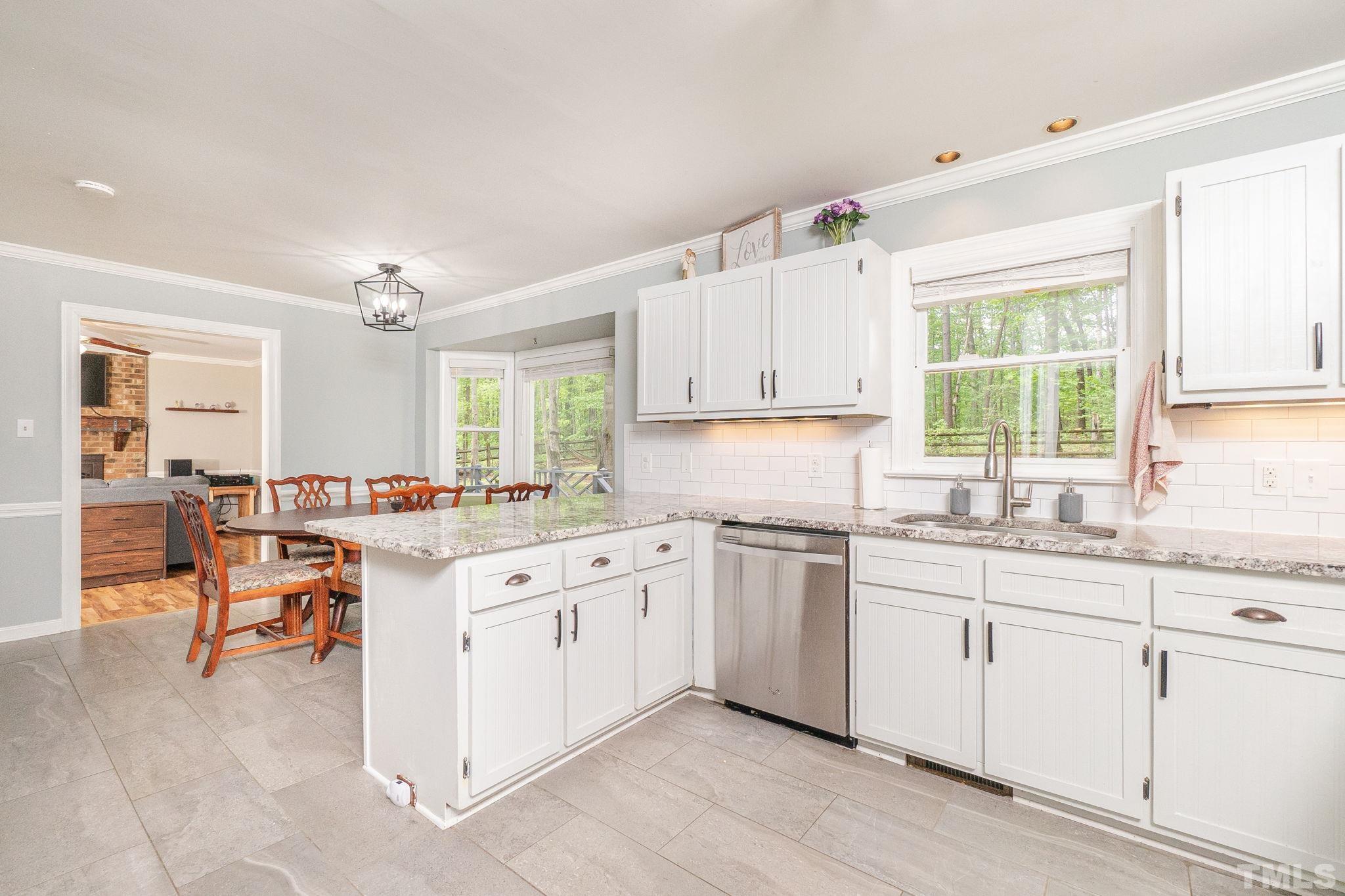 6313 Craig Road Durham, NC 27712 - Photo 18 of 38 a kitchen with a sink stove and cabinets