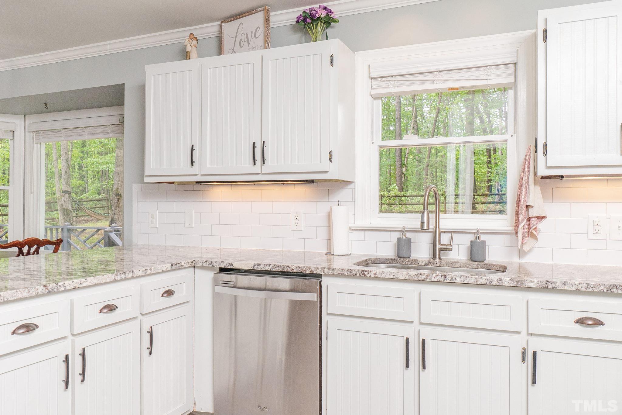 6313 Craig Road Durham, NC 27712 - Photo 20 of 38 a kitchen with granite countertop white cabinets and a window