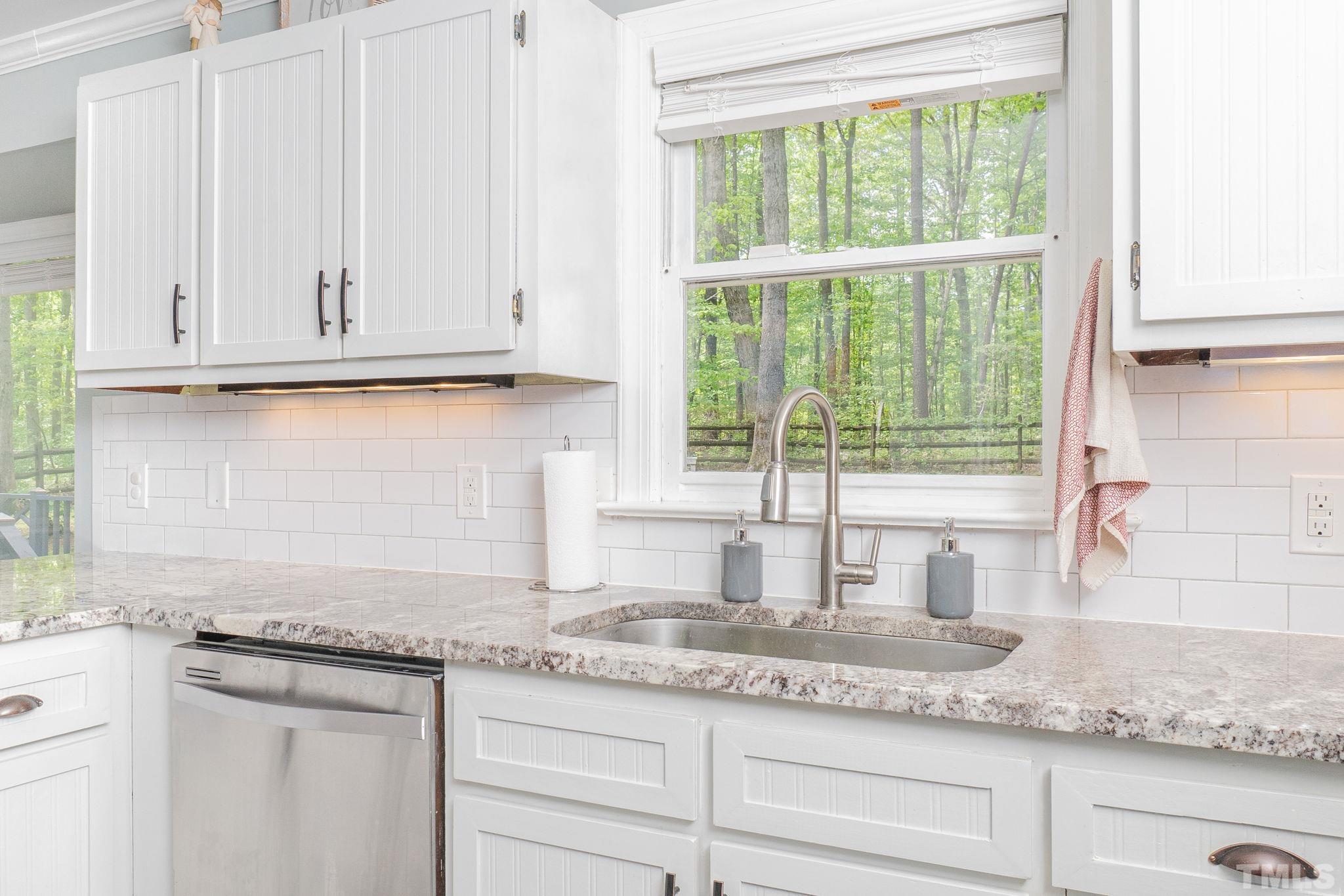 6313 Craig Road Durham, NC 27712 - Photo 23 of 38 a kitchen with granite countertop stainless steel appliances white cabinets and a granite counter tops