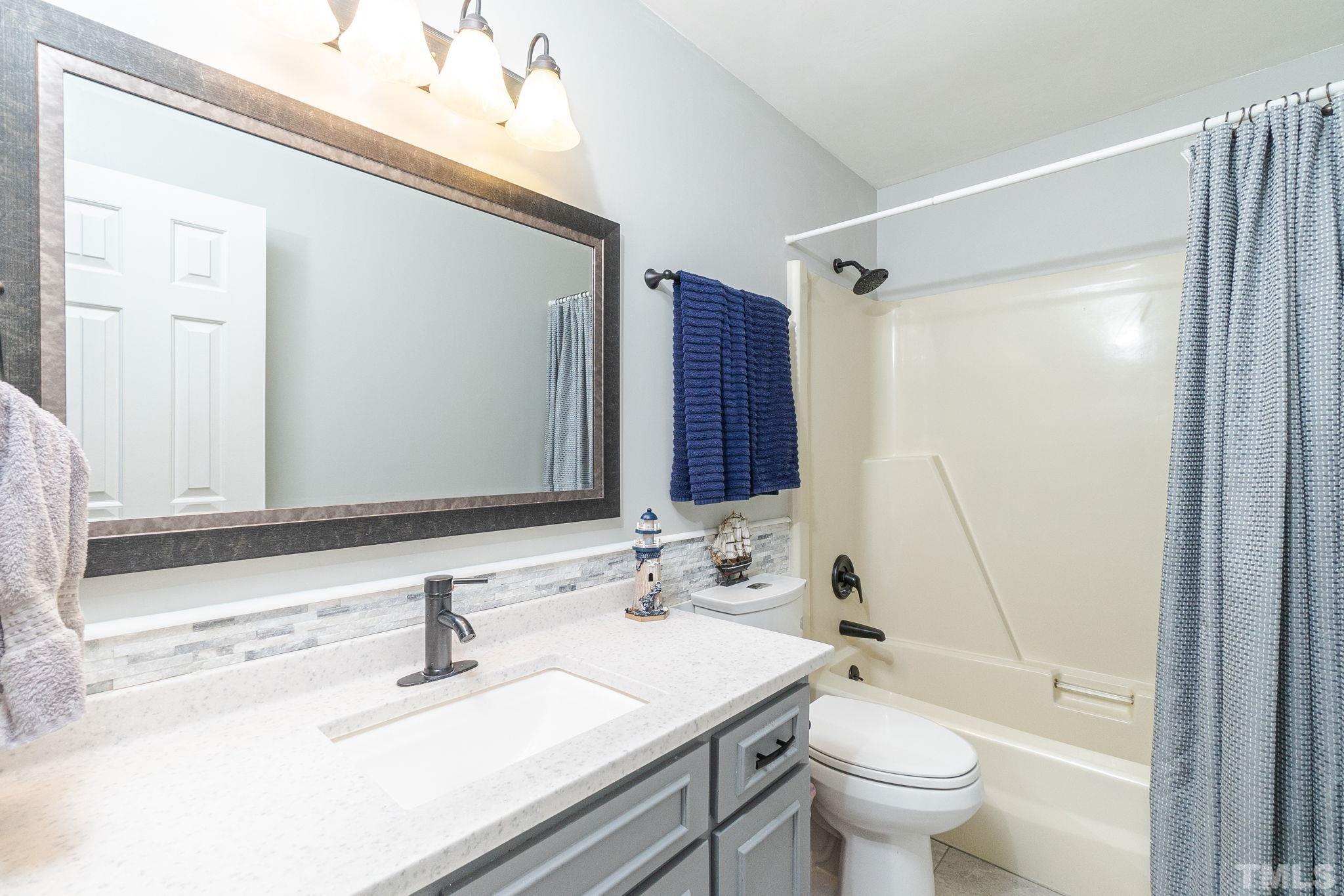 6313 Craig Road Durham, NC 27712 - Photo 32 of 38 a bathroom with a sink and a mirror