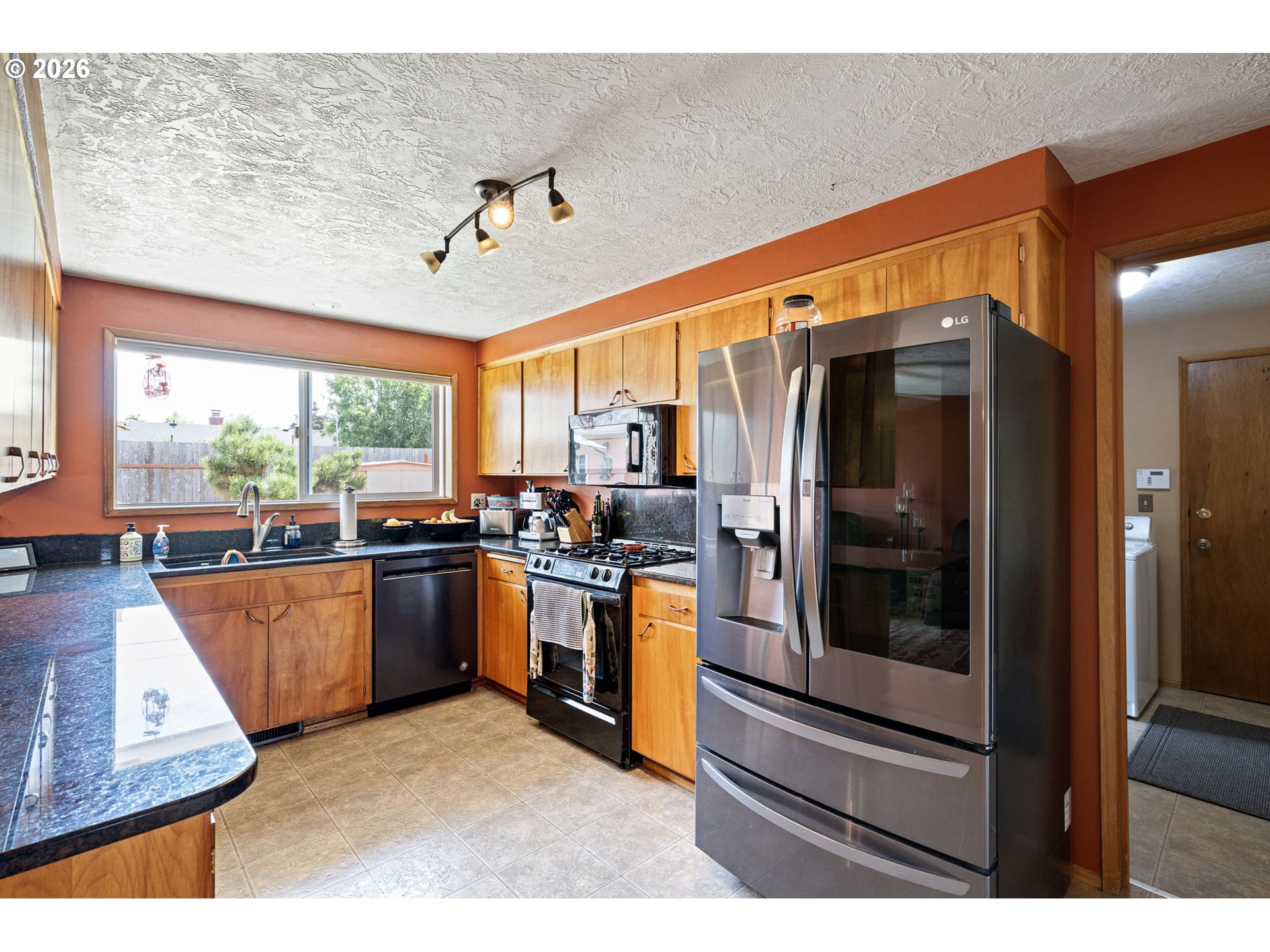 2465 17th Street Springfield, OR 97477 - Photo 13 of 47 a kitchen with stainless steel appliances granite countertop a refrigerator and wooden cabinets