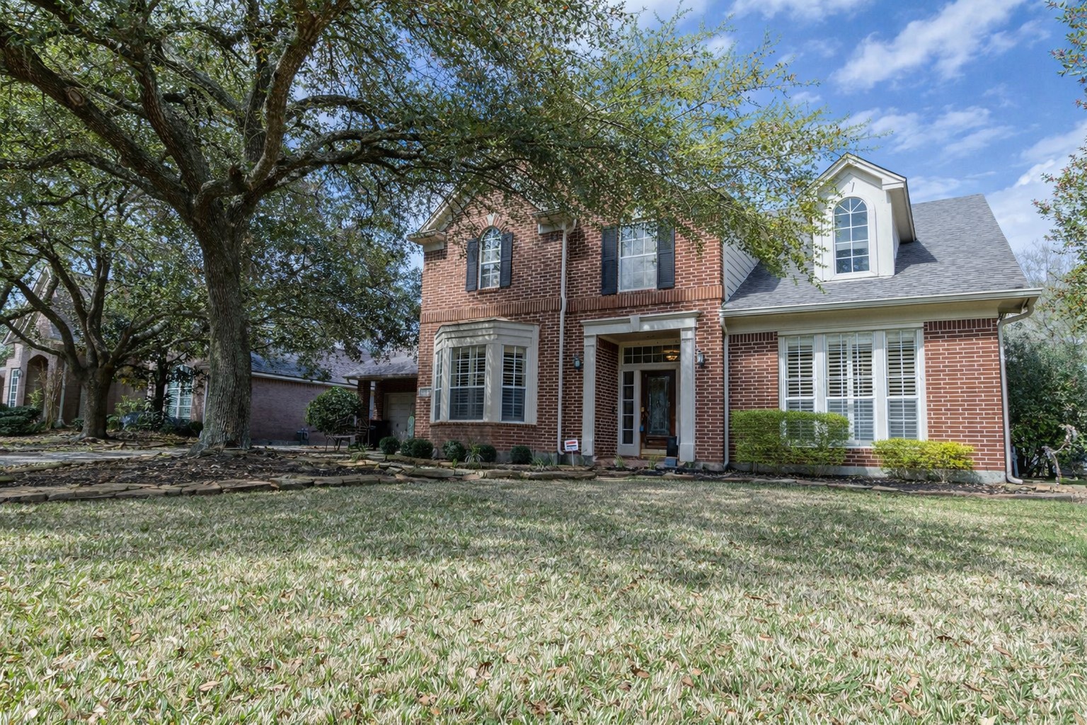 5718 Oakmoss Trail Spring, TX 77379 - Photo 3 of 50 Inviting brick exterior with charming front sitting area and mature landscaping creates welcoming curb appeal.