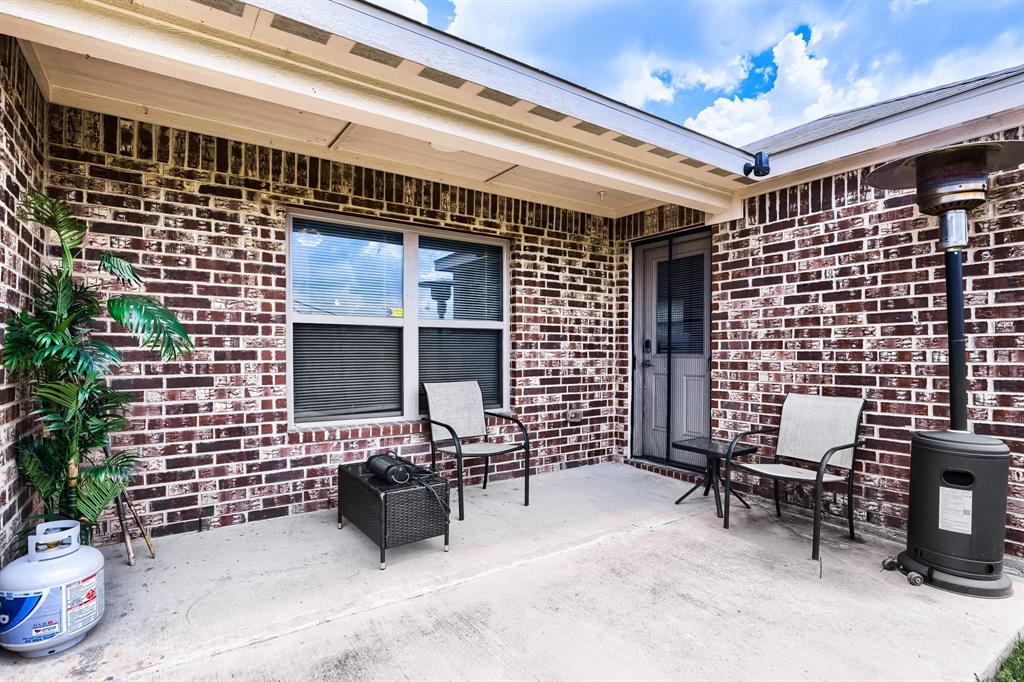 4309 Cat Tail Way Forney, TX 75126 - Photo 28 of 30 Concrete patio area with brick exterior and a privacy door