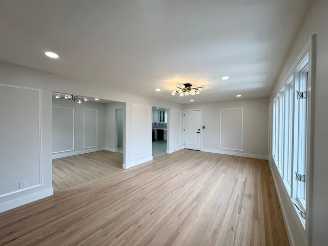 a view of empty room with wooden floor