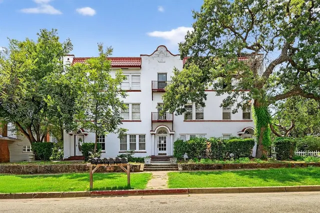 a view of a building with a yard and plants