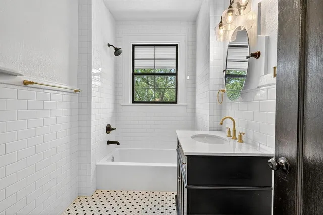 a bathroom with a bathtub a sink and a window