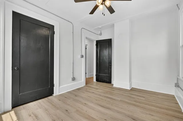 a view of an empty room with window and wooden floor