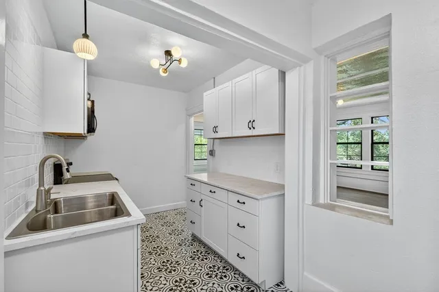 a kitchen with cabinets appliances and a window