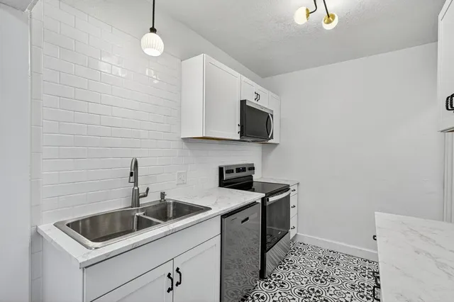 a kitchen that has a sink and a stove top oven