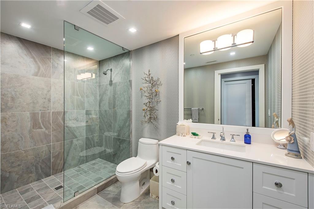 13915 Old Coast Road, Unit 302 Naples, FL 34110 - Photo 13 of 40 a bathroom with a double vanity sink toilet and shower