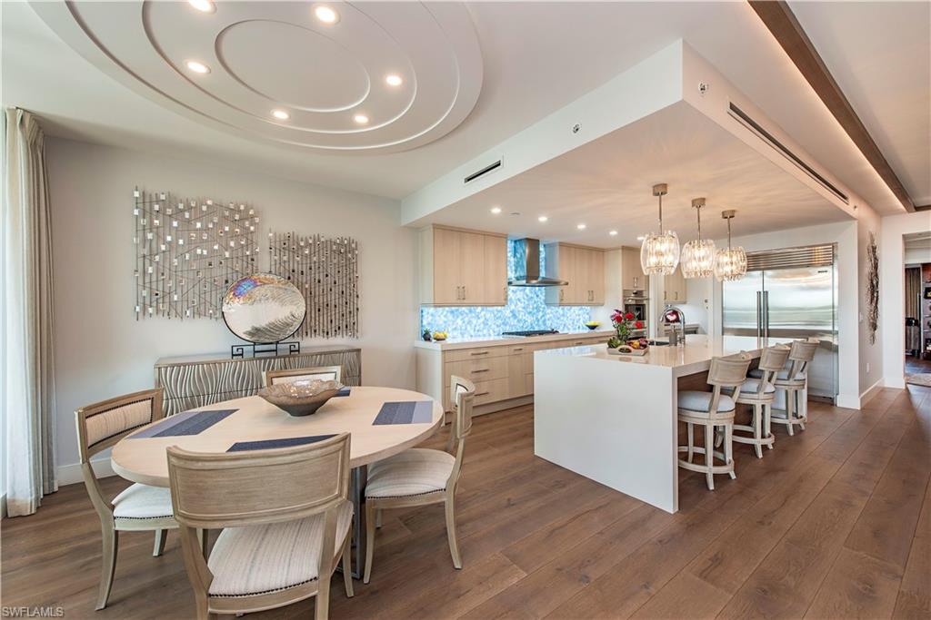 13915 Old Coast Road, Unit 302 Naples, FL 34110 - Photo 5 of 40 a kitchen and a dining room with wooden floor