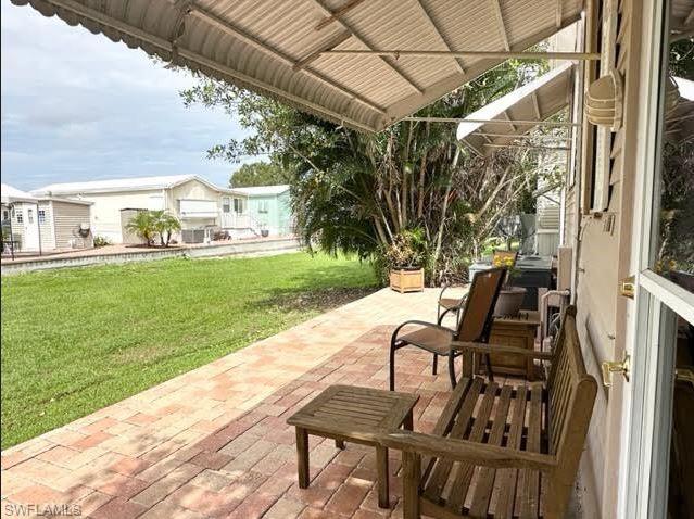 186 Panther Pass Circle, Unit 186 Naples, FL 34114 - Photo 9 of 50 a view of a patio with chair and table of the backyard