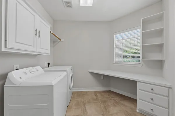 a utility room with cabinets washer and dryer