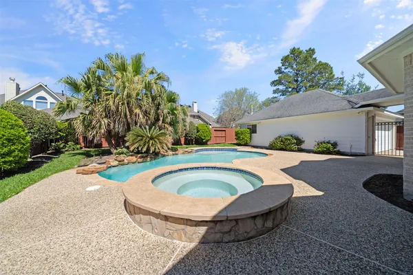 a swimming pool with outdoor seating and plants
