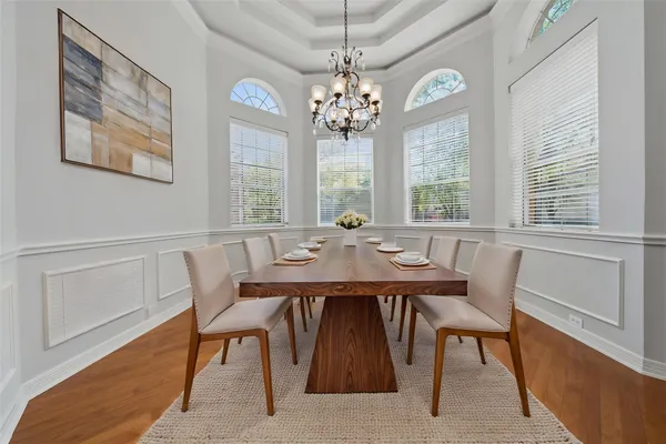 a view of a dining room with furniture a chandelier and wooden floor