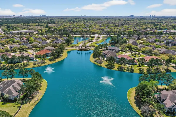 an aerial view of residential houses with outdoor space and river