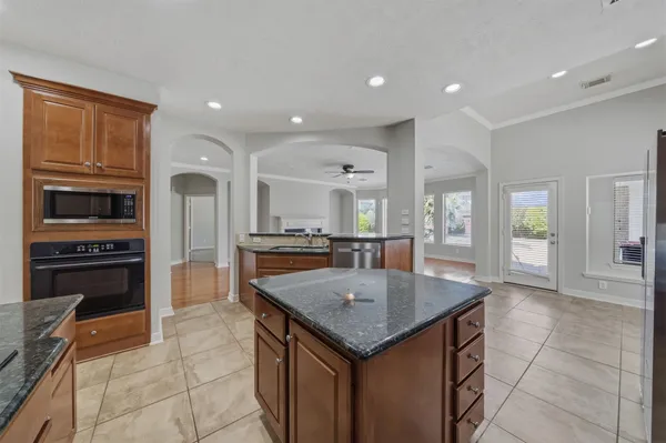 a kitchen with granite countertop a stove cabinets and refrigerator